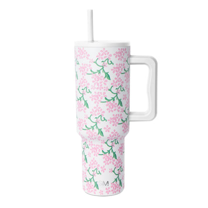 White insulated tumbler with handle and lid featuring pink flowers and green foliage pattern, Simple Modern logo, against white background.