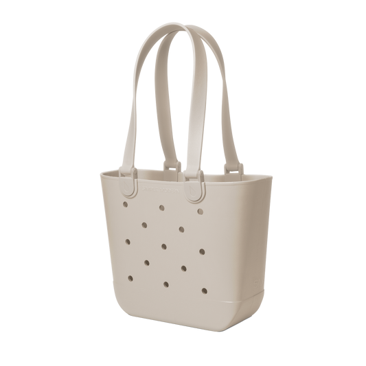 Cream-colored tote bag with handles and small circular perforations throughout the body, displayed on a neutral background.